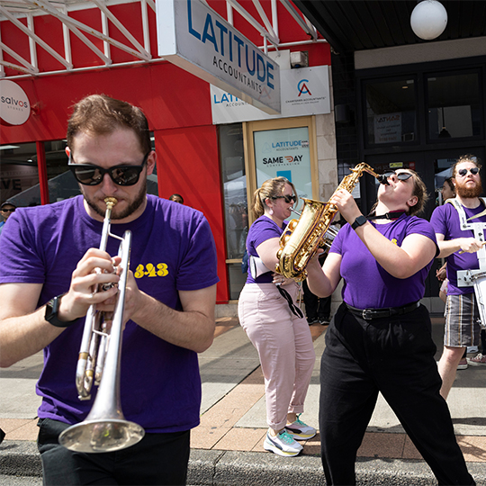 Two musicians play brass in the street